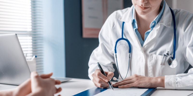 Doctor writing notes during a patient consultation