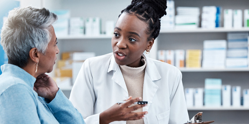 Pharmacist consulting with an older female patient